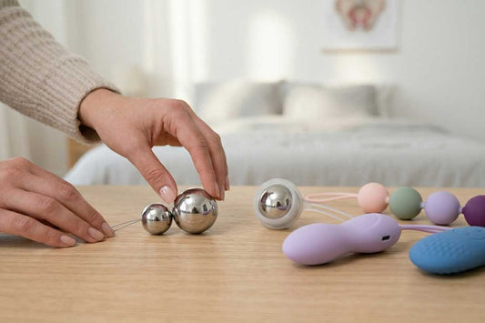 Bolas chinas y juguetes de bienestar íntimo sobre mesa para fortalecer el suelo pélvico y mejorar el autocuidado