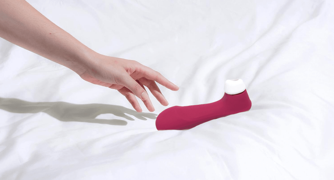 Succionador de clítoris Satisfyer sobre la cama en demostración del producto